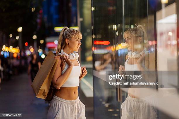 mujer mirando el escaparate de compras en una calle - colección de la moda fotografías e imágenes de stock