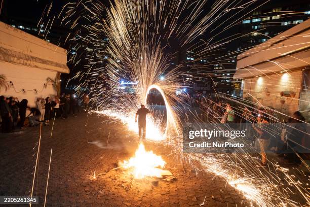 An Iranian man performs with fire while participating in the annual ''Chahar Shanbeh Soori,'' also known as the fire festival, in western Tehran,...