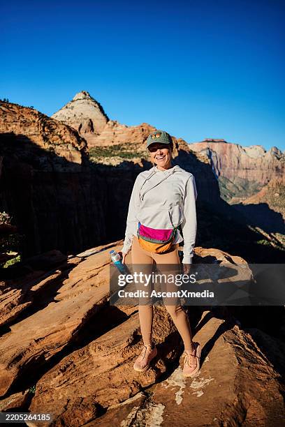 woman hikes through desert landscape - waist pack stock pictures, royalty-free photos & images