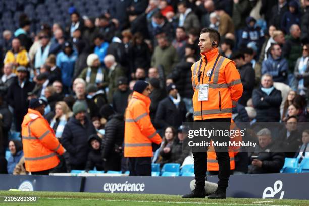 Matchday stewards guard the pitch during the Premier League match between Manchester City FC and Brighton & Hove Albion FC at Etihad Stadium on March...