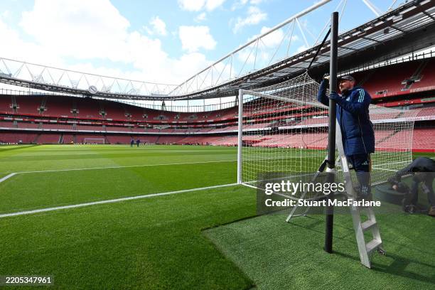 Members of the ground staff prepare the goal prior to the Premier League match between Arsenal FC and Chelsea FC at Emirates Stadium on March 16,...