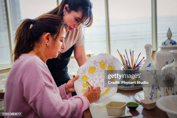 women working in ceramic workshop, making hand painted plate - porcelain texture stock pictures, royalty-free photos & images