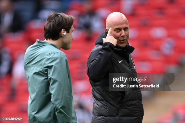Arne Slot, Manger of Liverpool, gestures as he talks to Federico Chiesa of Liverpool during the pitch inspection prior to the Carabao Cup Final...