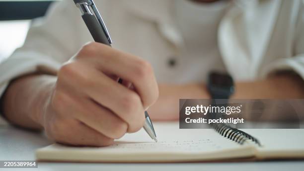young man taking notes. - college student writing paper stock pictures, royalty-free photos & images