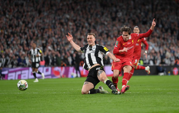 Federico Chiesa of Liverpool scores his team's first goal whilst under pressure from Dan Burn of Newcastle United during the Carabao Cup Final...