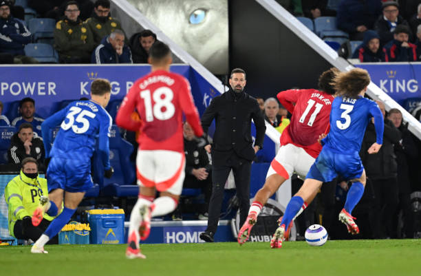 Ruud van Nistelrooy, Manager of Leicester City, looks on, as Joshua Zirkzee of Manchester United battles for possession with Marc Cucurella of...