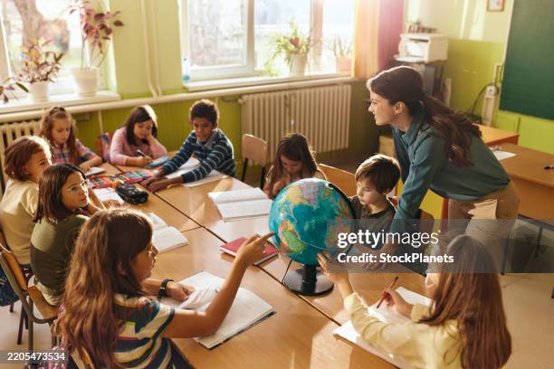 happy teacher having geography class with her students at school. - physical geography stock pictures, royalty-free photos & images