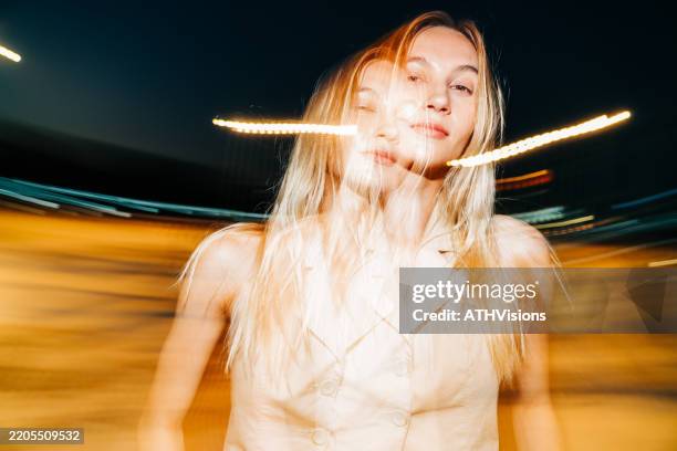 surreal double exposure portrait of a blonde woman with motion blur at night - flash equipamento fotográfico imagens e fotografias de stock
