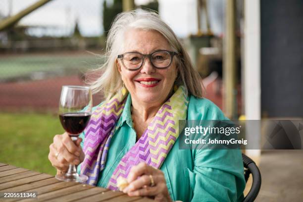 happy senior woman holding glass of red wine - pokolbin stock pictures, royalty-free photos & images
