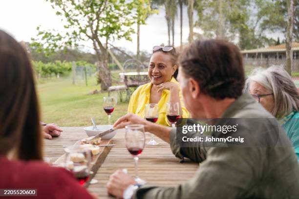 wine lovers enjoying refreshments outdoors at tasting event - pokolbin stock pictures, royalty-free photos & images