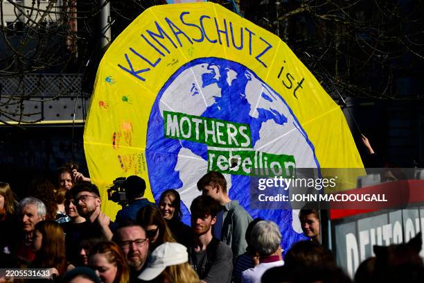 Participants display a placard reading 'Climate protection is mothers rebellion' in Berlin on March 21 during a climate strike organised by...