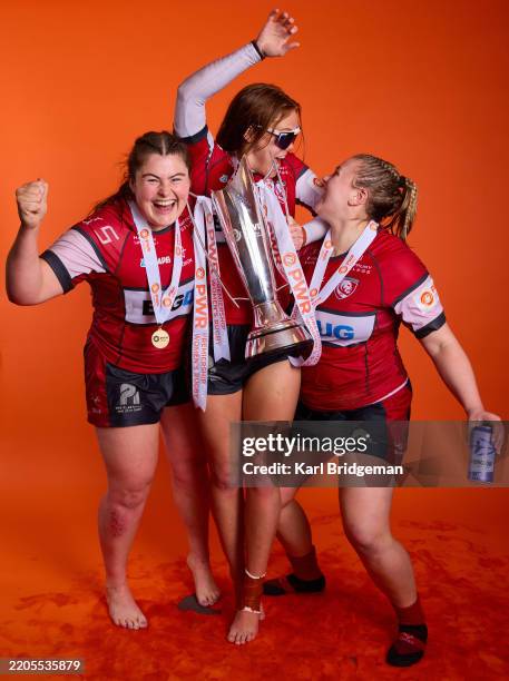 Maud Muir, Mia Venner and Mackenzie Carson of Gloucester-Hartpury pose for a portrait with the Premiership Women's Rugby Trophy after...