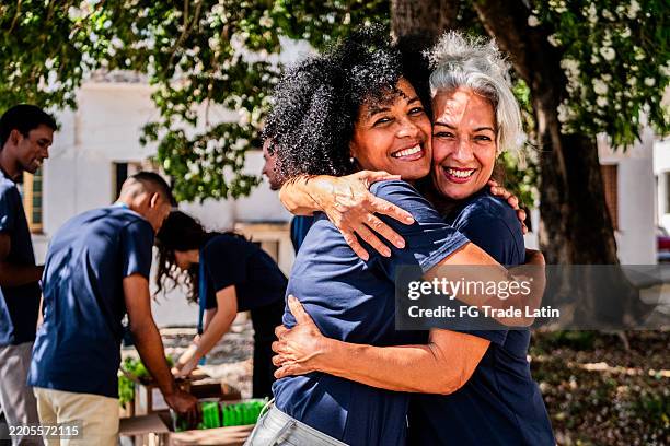 retrato de amigos voluntarios abrazados al aire libre - generosidad fotografías e imágenes de stock