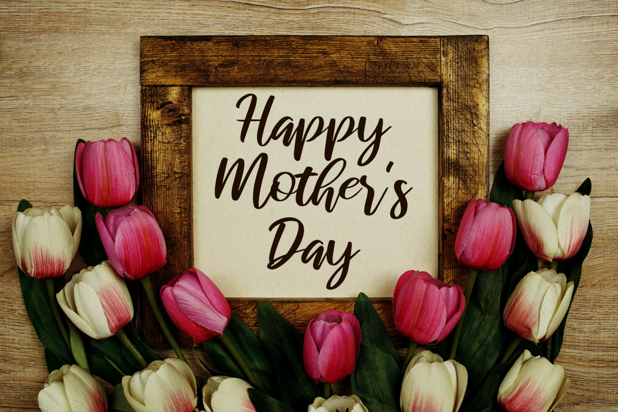 Happy Mother's Day text with tulip flowers bouquet on wooden background Happy Mother's Day text with tulip flowers bouquet on wooden background