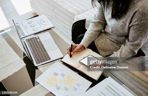 focused woman writing notes with laptop and smartphone - administrator stock pictures, royalty-free photos & images