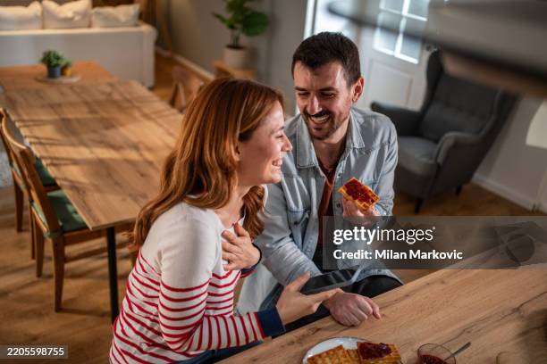 coppia felice che si gode waffle e marmellata a casa - marmellata di agrumi foto e immagini stock