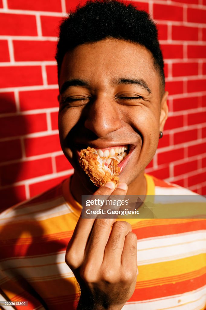 Young Man Enjoying Crispy Chicken