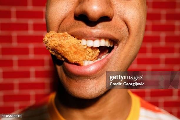 Young Man Enjoying Crispy Chicken High-Res Stock Photo