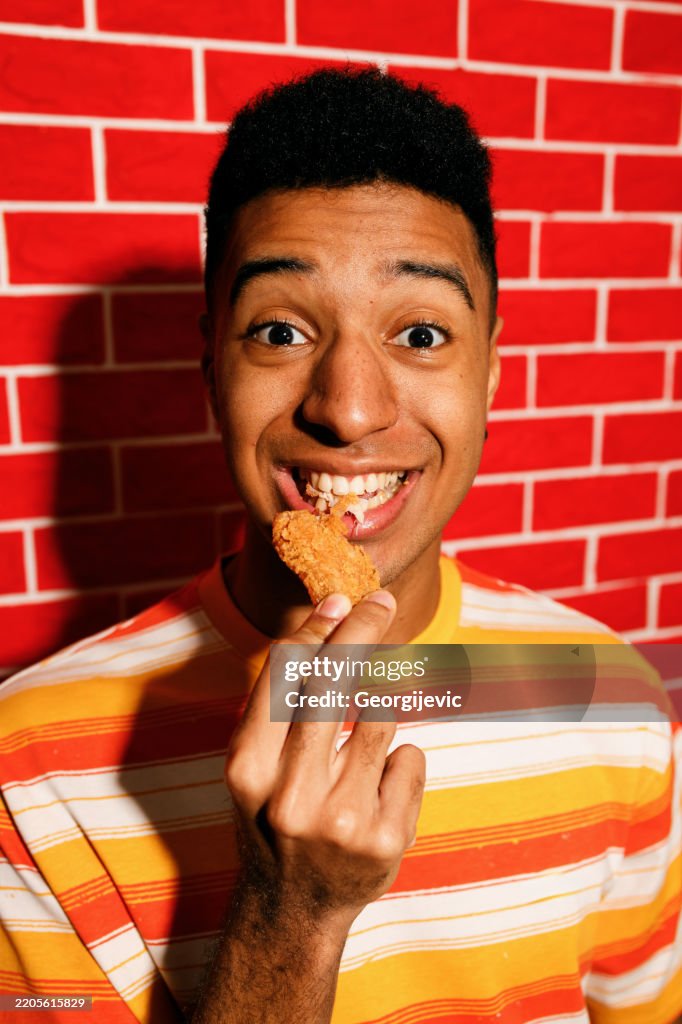 Young Man Enjoying Crispy Chicken