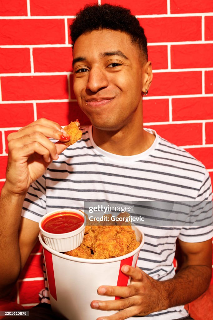 Young Man Enjoying Crispy Chicken