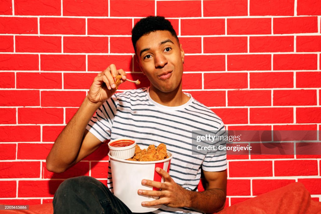 Young Man Enjoying Crispy Chicken