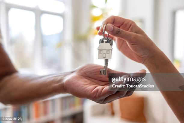 agent immobilier remettant les clés d’une nouvelle maison à un homme - clé photos et images de collection