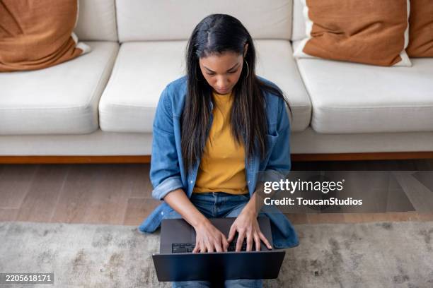 woman working at home using her laptop - person of colour stock pictures, royalty-free photos & images