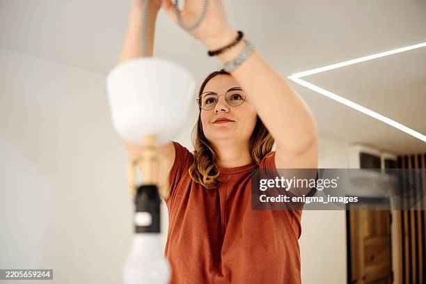 change the lamp chandelier - installing ceiling light fixture stock pictures, royalty-free photos & images