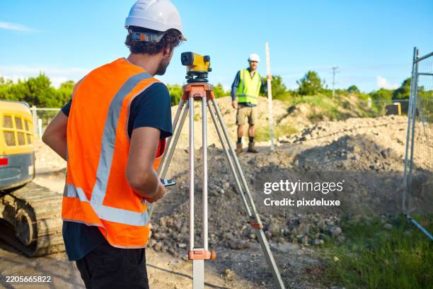engineers planning road construction using theodolite and staff - surveyor stock pictures, royalty-free photos & images