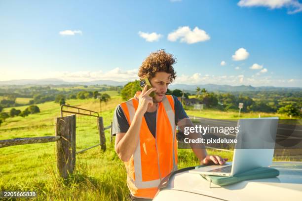 australian engineer planning construction project in rural landscape using laptop and phone - reflective clothing stock pictures, royalty-free photos & images