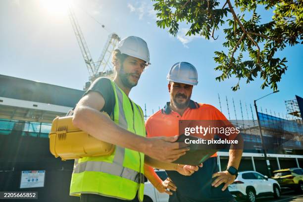 engineers discussing building plans at construction site in australia - hard hat stock pictures, royalty-free photos & images