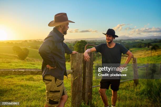 two australian farmers discussing by fence at sunset - cultures stock pictures, royalty-free photos & images