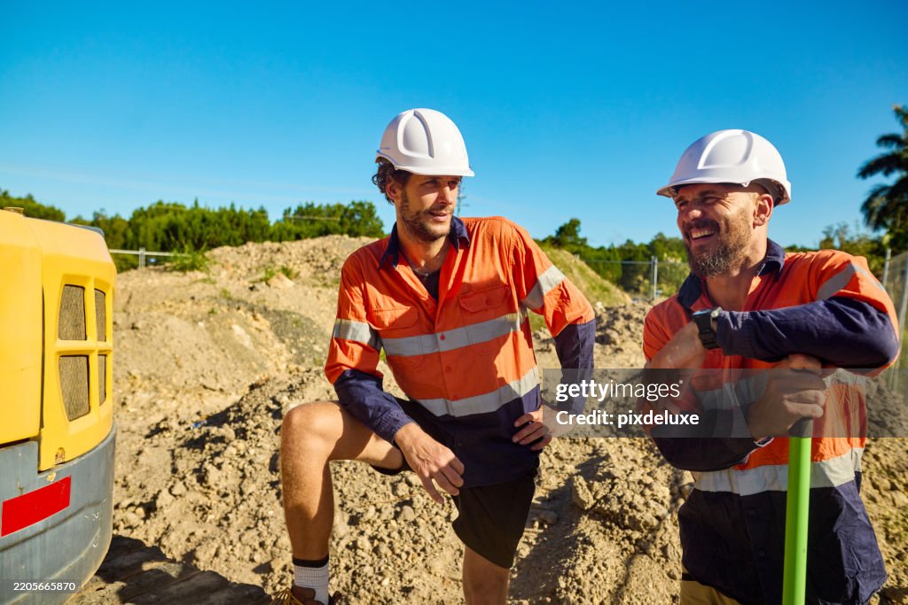 Australian engineers discussing near excavator at construction site in new south wales