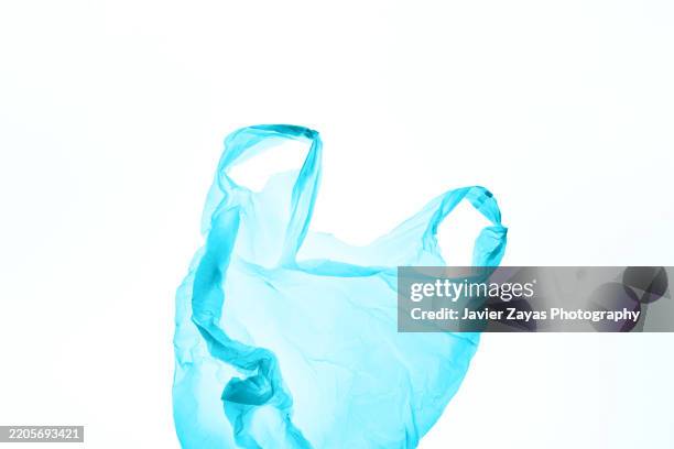 light blue plastic bag floating on white background - disposable stock pictures, royalty-free photos & images