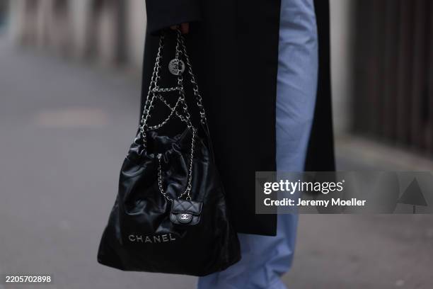 Maria Barteczko seen wearing Papermoon black shoulder padded oversized wool long coat, Arket blue striped cotton pajama loungewear pants and Chanel...