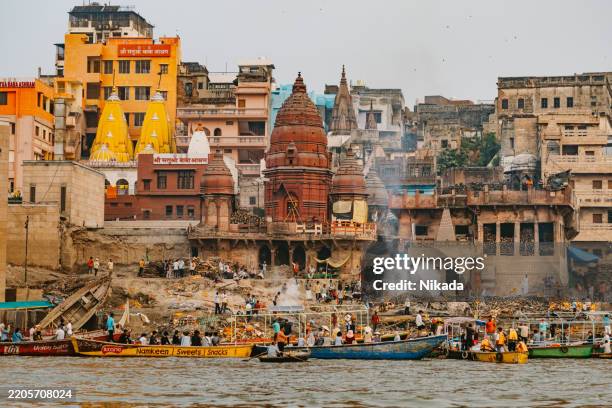 varanasi holy city along the ganges river with religious temples and boats - pilgrimage stock pictures, royalty-free photos & images