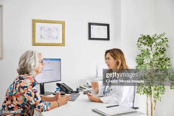physician giving advice to elderly patient - cuidados de saúde primários imagens e fotografias de stock