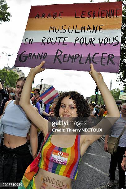 Une jeune femme tient une pancarte "Arabe lesbienne musulmane en route pour vous grand remplacer" lors de la marche des fiertés organisée par...