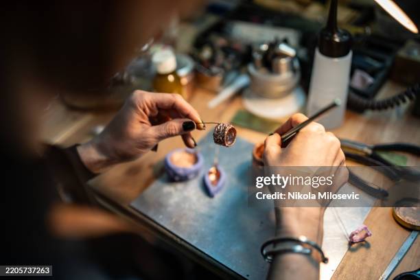 artisan crafting jewelry with intricate details in a workshop setting - customised stock pictures, royalty-free photos & images