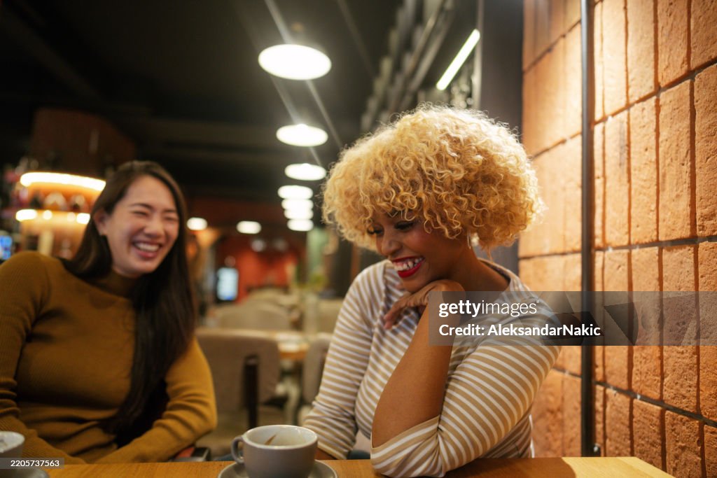 Two ladies enjoy vivid conversation over a cup of coffee
