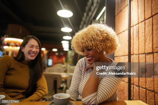 Two Ladies Enjoy Vivid Conversation Over A Cup Of Coffee High-Res Stock Photo