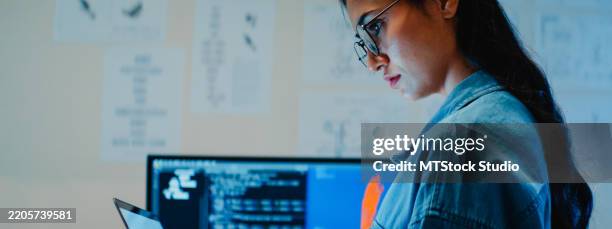 young female engineer working late on a robotic arm prototype in tech lab at night. machine learning, computer-aided manufacturing, innovation and creativity. ai and robotics development. - web prototype stock pictures, royalty-free photos & images