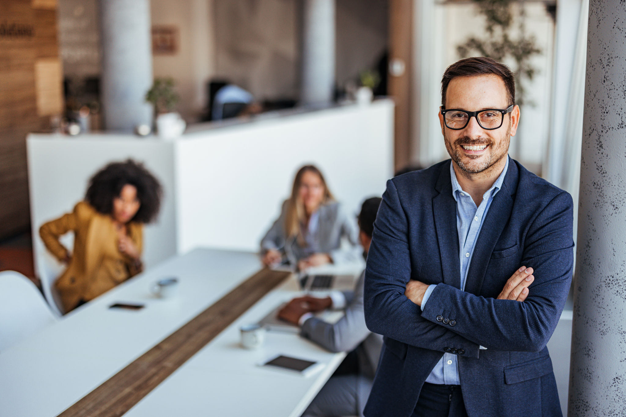 Confident Businessman Leading a Team Meeting in a Modern Office Environment Confident Businessman Leading a Team Meeting in a Modern Office Environment