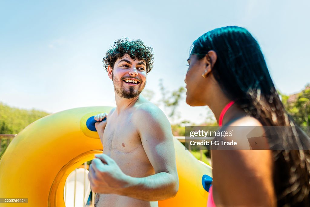 Friends talking while waiting to go on a water park slide