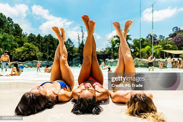 friends sunbathing at a water park - poolside gathering stock pictures, royalty-free photos & images