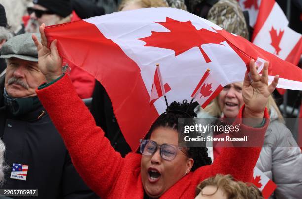 Person chants during the Elbows Up rally. They wore red and plaid, they carried signs and flags, they chanted "elbows up". Hundreds gathered in...