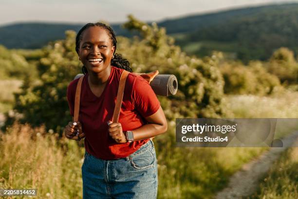 young black woman carrying yoga mat hiking in nature - figura feminina imagens e fotografias de stock