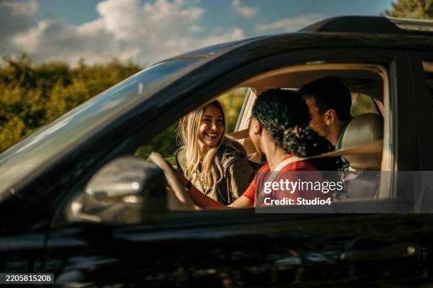 people laughing and talking during a car trip - interior de carro imagens e fotografias de stock