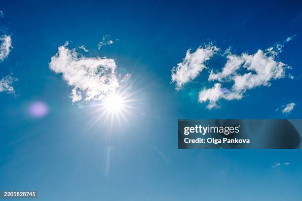 bright sun shining through fluffy white clouds in deep blue sky - luz ultravioleta eletromagnético imagens e fotografias de stock