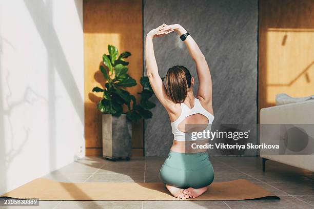 young beauty woman doing yoga at home - strekken stockfoto's en -beelden